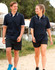 A navy unisex polo shirt with contrasting white trim, worn by a man and woman walking outdoors.