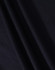 A close-up view of dark navy fabric showcasing its texture and drape. The material appears smooth and woven.