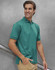 A men's sustainable poly/cotton polo shirt in green, featuring a collar and short sleeves, displayed on a model.