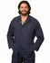 A man wearing a navy blue cotton drill coverall with multiple pockets and a logo.