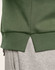 A green crew neck sweater featuring ribbed hem details and a split at the bottom, paired with grey joggers.