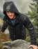 A unisex quilted waterproof jacket in black, featuring a hood, worn by a person outdoors.