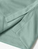 A close-up of a light green sustainable jacquard knit fabric, featuring textured detailing and stitching.