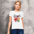 A white women's organic t-shirt featuring floral graphics and a logo on a textured background.