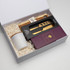 A gift box containing a cheese board, gold cheese knives, and a ceramic container, all set in white paper fill.