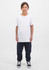 A child wears a white t-shirt and navy track pants, standing against a plain white background. The outfit features a logo.