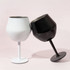 A white and a black detachable wine glass, featuring sleek designs and a modern finish, leaning against each other.