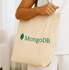 A natural beige tote bag with a logo on one side. The bag features sturdy handles for easy carrying.