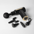 A black and gold massage gun with multiple attachments and a charging cable. It features a logo on the handle.