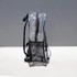 A clear stadium backpack in transparent PVC with black straps and a mesh pocket at the bottom.