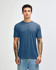 A blue American Apparel tri-blend T-shirt displayed on a model with tattoos, paired with denim jeans.