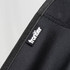 A black fabric showing stitching and a logo tag for a folding chair.