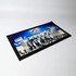 A rectangular bar runner featuring a black border with a group photo and blue background. Displays a logo.