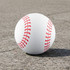 A high bounce baseball in white with red stitching, resting on a grey surface. The product has a logo.