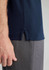 A dark navy blue men's polo shirt featuring a vented hem, with a model's hand visible holding the shirt.