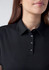 A women's short sleeve polo in black with a collar and button details, featuring a subtle logo.