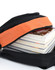 A black backpack with an orange accent unzipped to reveal stacked magazines inside.
