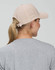 A beige Jacquard Texture 5 Panel Cap with a back ponytail opening, worn by a person with long hair.