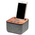 A Bluetooth speaker in grey fabric with a wooden top, featuring a slot for a smartphone and control buttons.