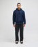 A navy blue pullover hooded sweatshirt with a front pocket and drawstring hood, paired with dark trousers.