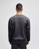 A grey Champion Powerblend® adult crewneck sweatshirt viewed from the back, featuring a logo.