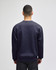 A navy crewneck sweatshirt displayed from the back, featuring long sleeves and a simple design. It has a logo.