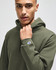 A green hooded sweatshirt with a fitted design and a small logo on the sleeve, worn by a model.