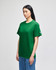 A green Champion adult short-sleeve t-shirt displayed on a model, featuring a logo on the sleeve.
