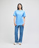 A blue short-sleeve t-shirt displayed on a model, paired with loosely fitted jeans. The shirt features a logo.