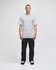 A model stands in a grey Champion adult short-sleeve T-shirt, paired with black pants. The shirt features a logo.
