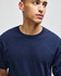 A navy blue Champion adult short-sleeve t-shirt displayed on a model. The t-shirt features a logo.