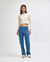 A fitted, long-sleeve, cropped t-shirt in beige, paired with blue jeans. The model stands on a plain background.