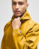 A packable anorak jacket in mustard yellow, featuring a hood and an adjustable neckline. It has a logo on the sleeve.