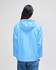 A lightweight, packable anorak jacket in light blue, featuring a hood and a logo on the back.