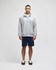 A grey quarter-zip pullover worn with navy shorts, featuring a logo on the sleeve.