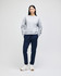 A grey women's crewneck sweatshirt paired with navy sweatpants and white sneakers, featuring a logo.