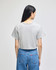 A cropped short sleeve grey t-shirt with a casual fit, featuring a logo on the back. 