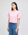 A pink cropped short sleeve t-shirt with a logo on the sleeve, paired with blue jeans.