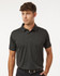 A men's polo shirt in dark heather grey with a collar and short sleeves. It features a logo on the chest.