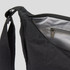 A black bag with a zippered opening and an interior pocket, featuring a sturdy strap. It has a simple, sleek design.