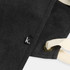 A dark grey canvas apron with cream-coloured straps and a small logo patch.