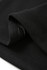 A close-up of a black polar fleece half zip top showing soft fabric and stitching details. The product features a logo.
