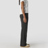 Faded cuffless track pants in dark grey, shown from the side on a person wearing a white shirt and light-coloured shoes.