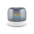 A compact speaker featuring a grey translucent cover and a white base, with branding on the front.