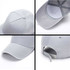 A light grey heavy acrylic sandwich cap featuring a curved brim and an adjustable strap at the back. It has a logo.
