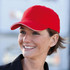 A red heavy acrylic sandwich cap with a contrasting trim, worn by a smiling woman. The cap has a logo.