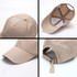 A beige six-panel cotton cap with a white brim, featuring a strap at the back and an inner lining.
