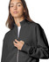 A woman wearing a black full-zip jacket with a high collar. The jacket has a logo on it.