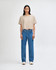 A beige cropped boxy t-shirt paired with blue straight-leg jeans, worn by a model against a plain backdrop.