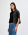 A black heavyweight cotton women's crop boxy T-shirt displayed on a model, featuring a relaxed fit.